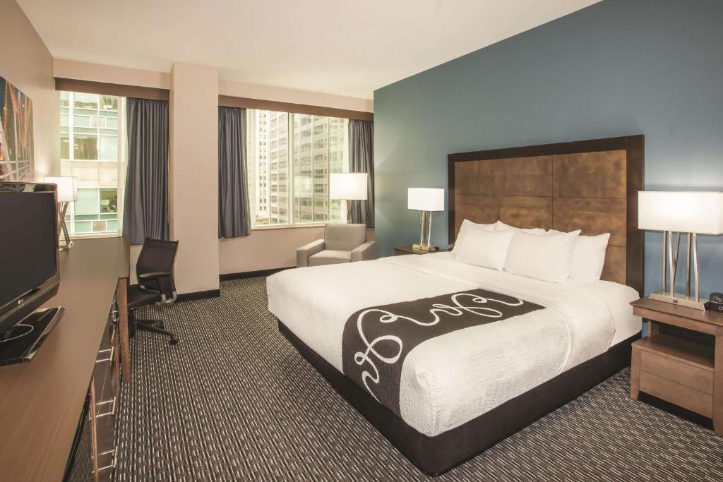 a hotel room with a large bed and a television at La Quinta Inn & Suites by Wyndham Chicago Downtown in Chicago