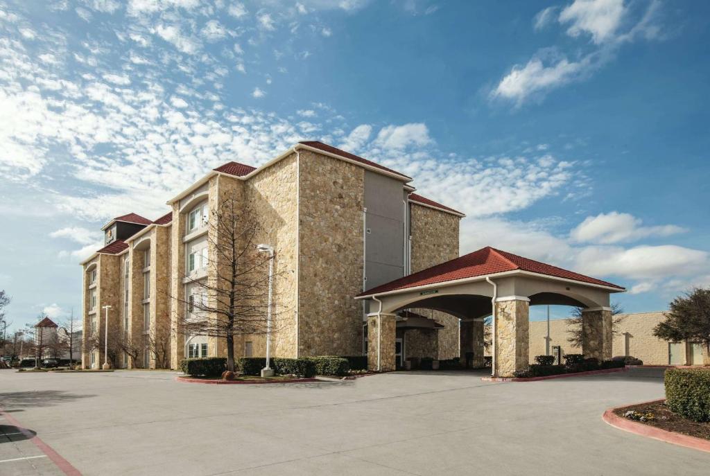 un gran edificio de ladrillo con un cenador en un aparcamiento en La Quinta by Wyndham Mansfield TX en Mansfield