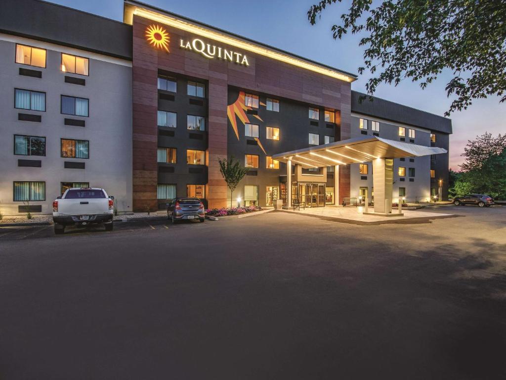 a hotel with a parking lot in front of it at La Quinta by Wyndham Hartford Bradley Airport in Windsor Locks