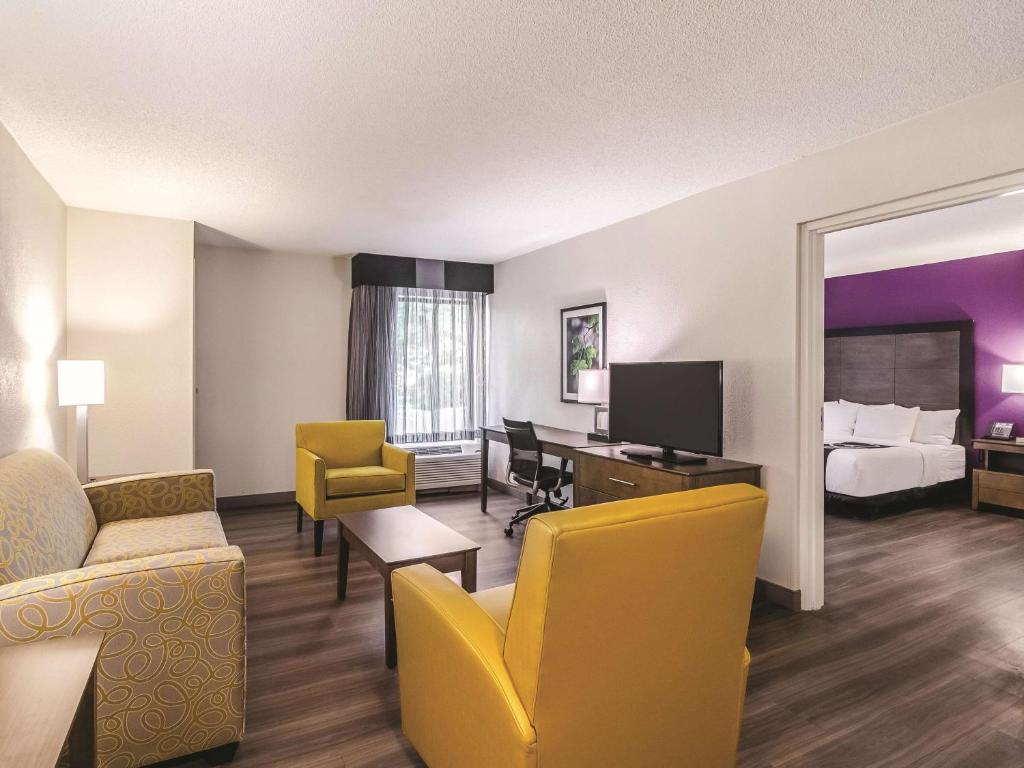 a hotel room with a bed and a living room at La Quinta by Wyndham Myrtle Beach - N. Kings Hwy in Myrtle Beach