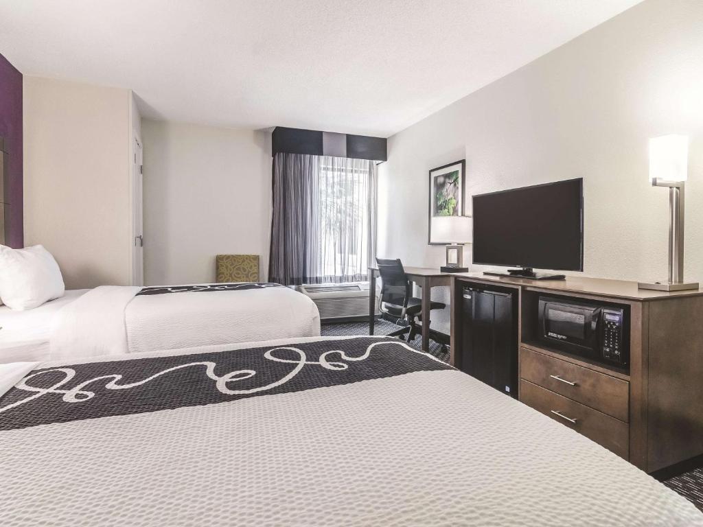 a hotel room with two beds and a flat screen tv at La Quinta by Wyndham Myrtle Beach - N. Kings Hwy in Myrtle Beach