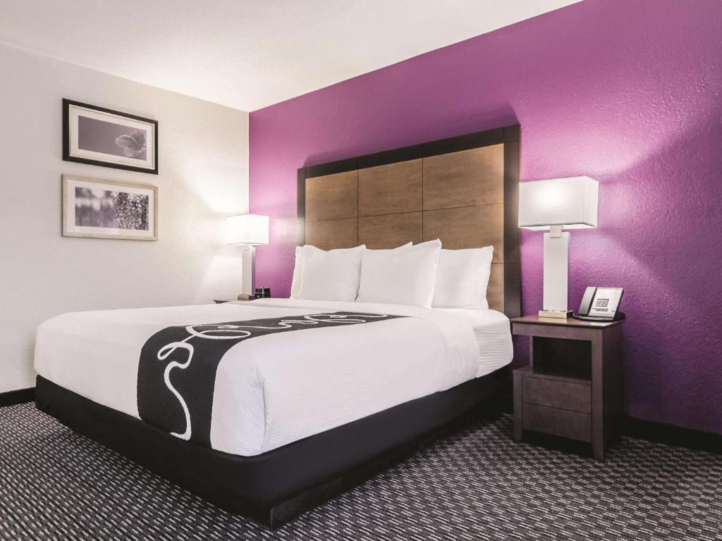 a hotel room with a large bed with purple walls at La Quinta by Wyndham Myrtle Beach - N. Kings Hwy in Myrtle Beach