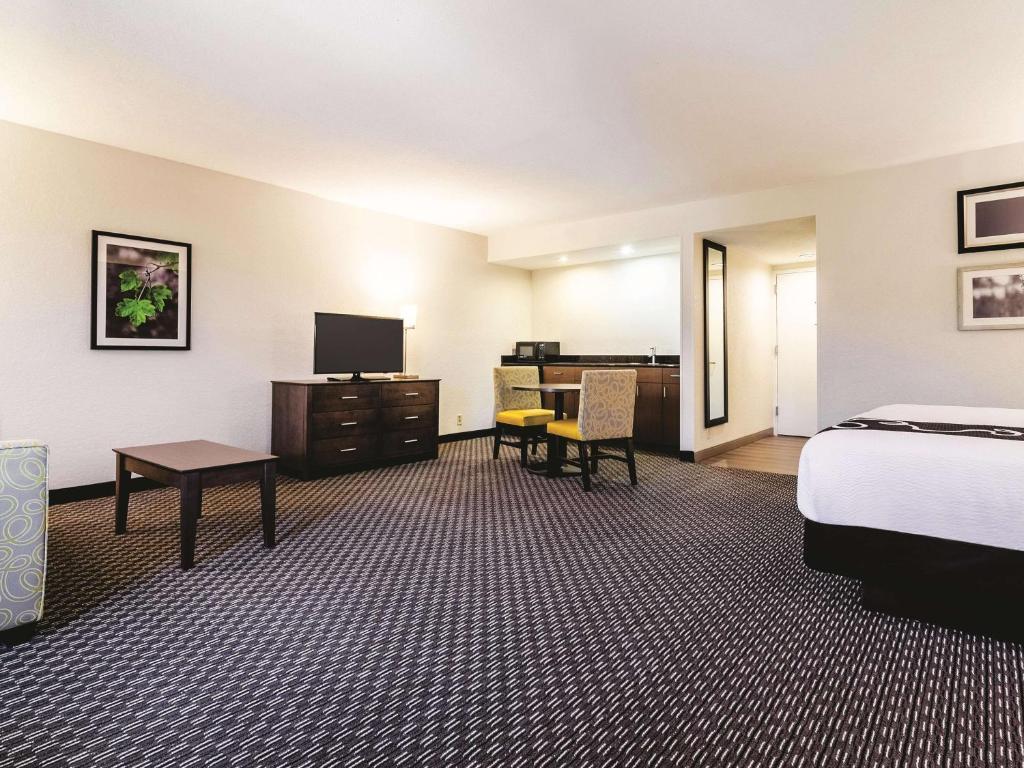 a hotel room with a bed and a desk at La Quinta by Wyndham Myrtle Beach - N. Kings Hwy in Myrtle Beach