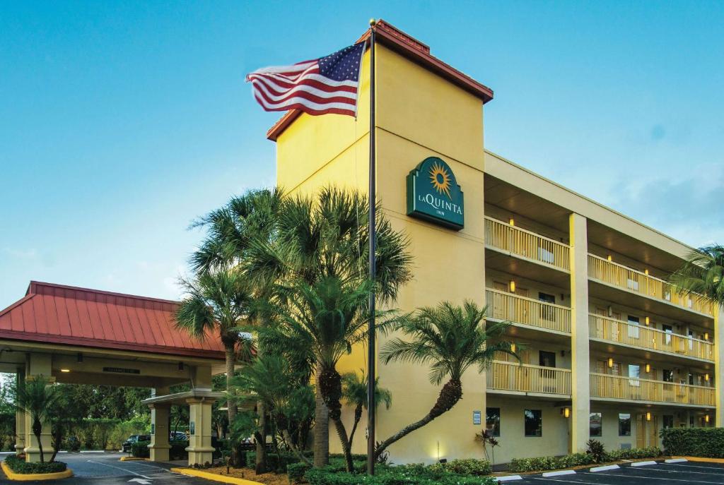 a hotel with an american flag in front of it at La Quinta Inn by Wyndham West Palm Beach - Florida Turnpike in West Palm Beach