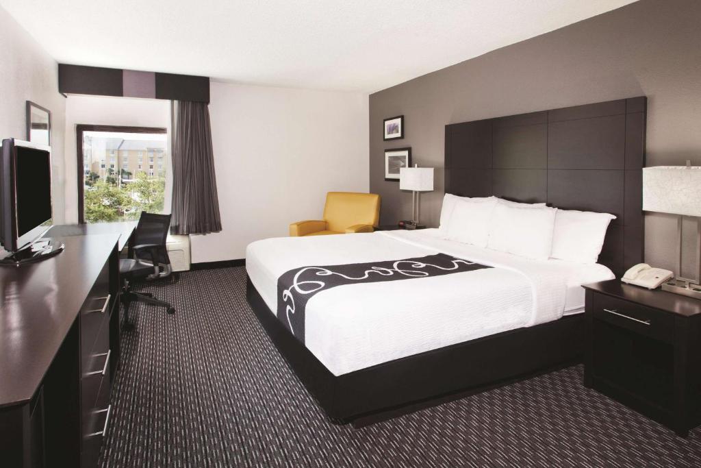 a hotel room with a large bed and a desk at La Quinta by Wyndham Charleston Riverview in Charleston
