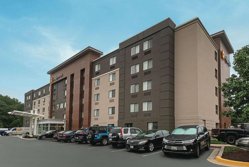 a parking lot with cars parked in front of a building at La Quinta by Wyndham Baltimore BWI Airport in Linthicum Heights