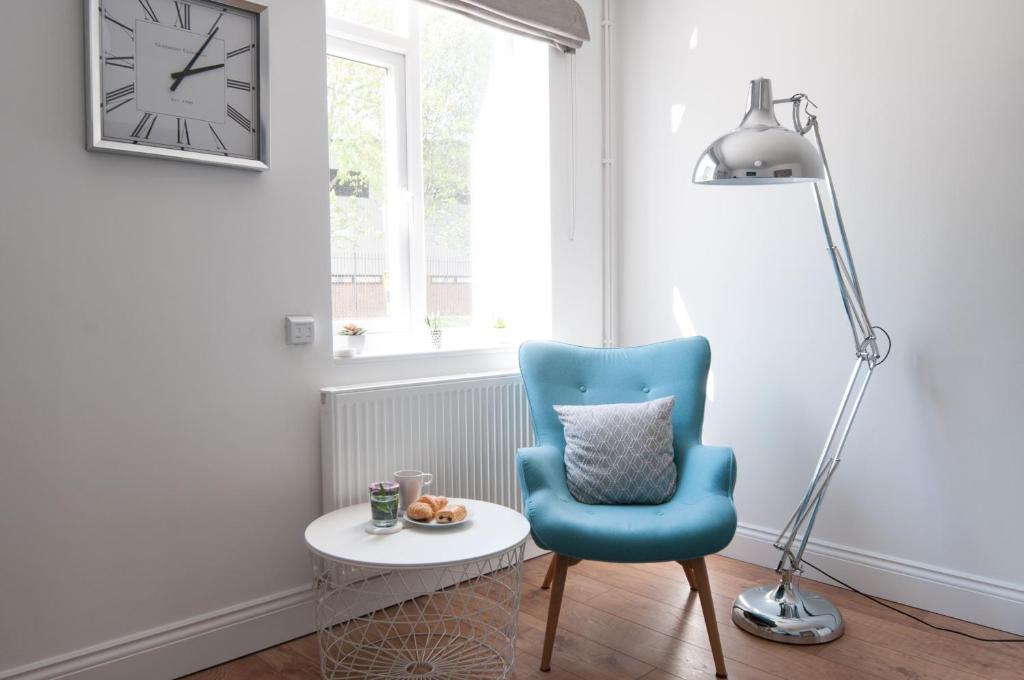 a living room with a blue chair and a lamp at The Wellington - Ideal for Professionals in Burton upon Trent