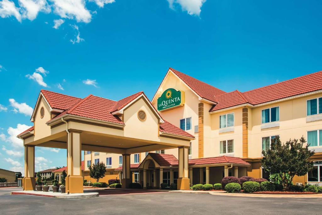 a hotel with a sign on the front of it at La Quinta by Wyndham Russellville in Russellville