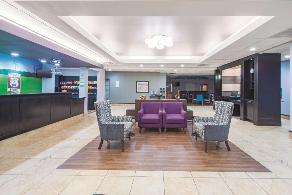 a lobby with purple chairs and a waiting area at La Quinta by Wyndham Tulsa Airport / Expo Square in Tulsa