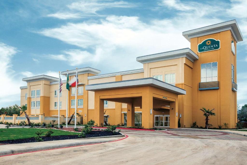 a large yellow building with a sign on it at La Quinta by Wyndham Cotulla in Cotulla