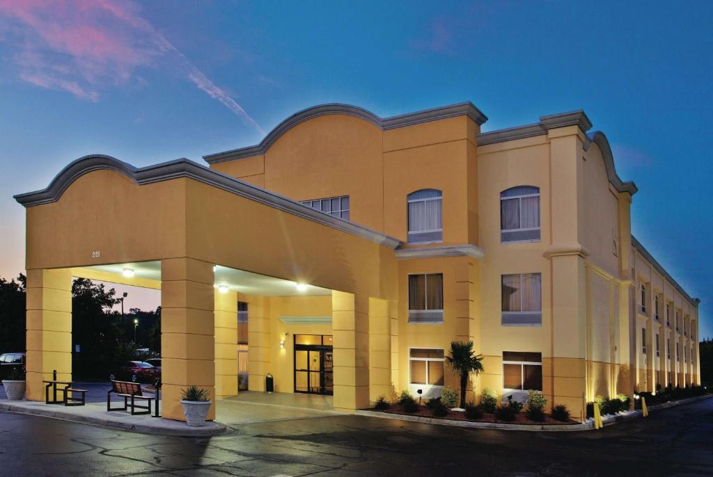 a large yellow building in a parking lot at La Quinta by Wyndham Florence in Florence