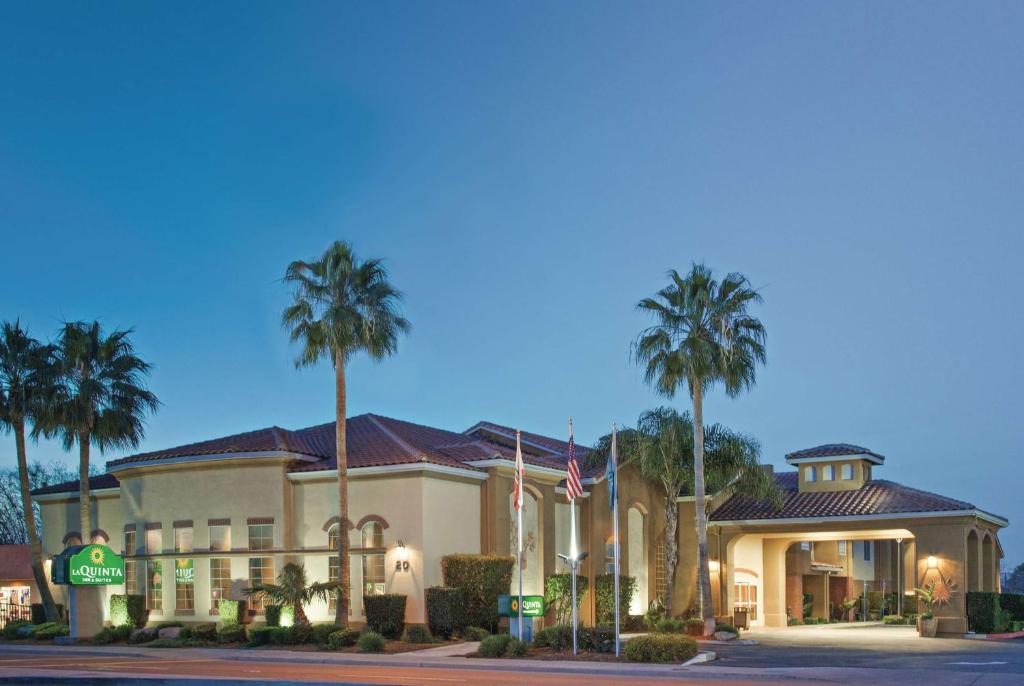 un hotel con palmeras frente a un edificio en La Quinta by Wyndham Los Banos, en Los Baños