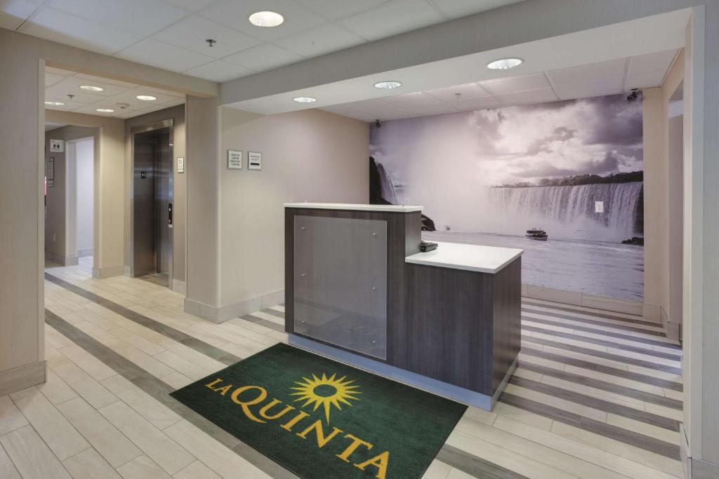 a lobby with a large tv and a painting on the wall at La Quinta by Wyndham Batavia in Batavia