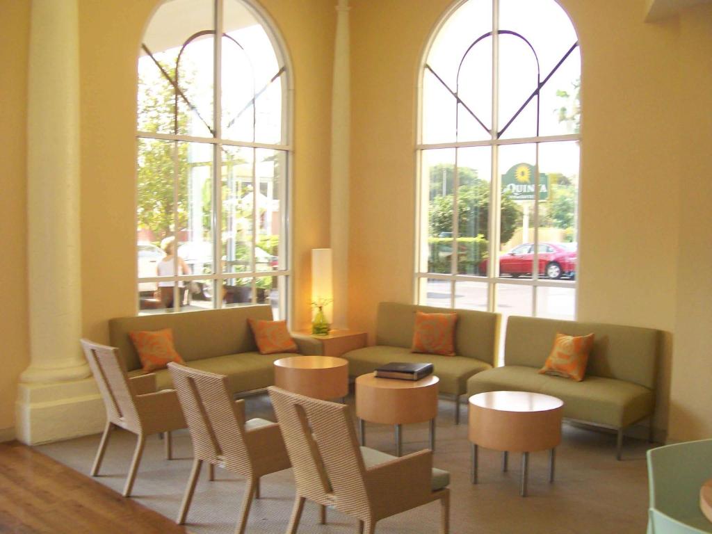 a living room with a couch and chairs and windows at La Quinta by Wyndham Sarasota Downtown in Sarasota