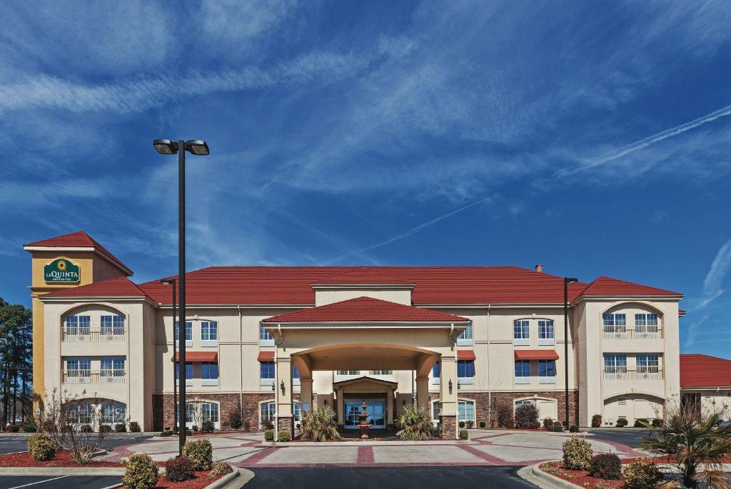 un gran edificio de oficinas con techo rojo en La Quinta by Wyndham Searcy, en Searcy