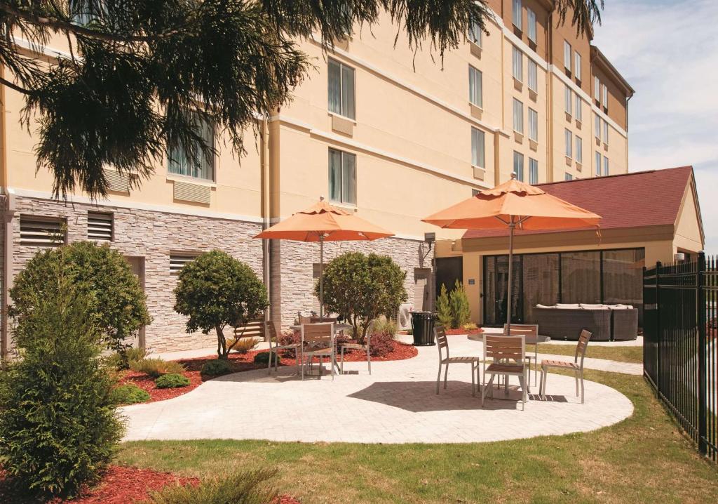 a patio with tables and umbrellas in front of a building at La Quinta by Wyndham Atlanta Airport North in Atlanta