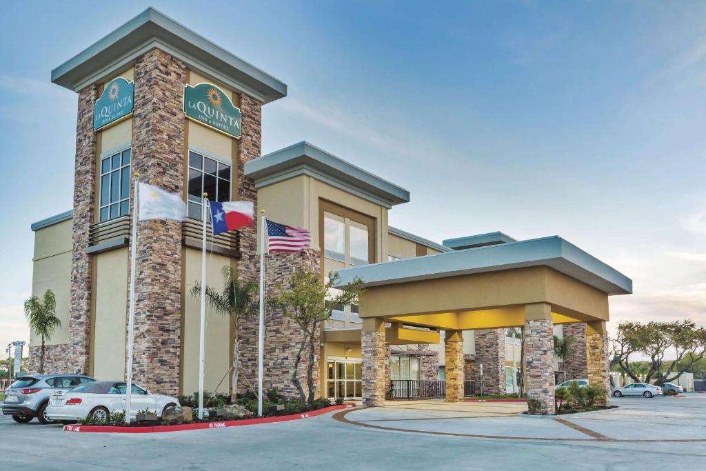 a hotel with two flags in a parking lot at La Quinta by Wyndham Rockport - Fulton in Rockport