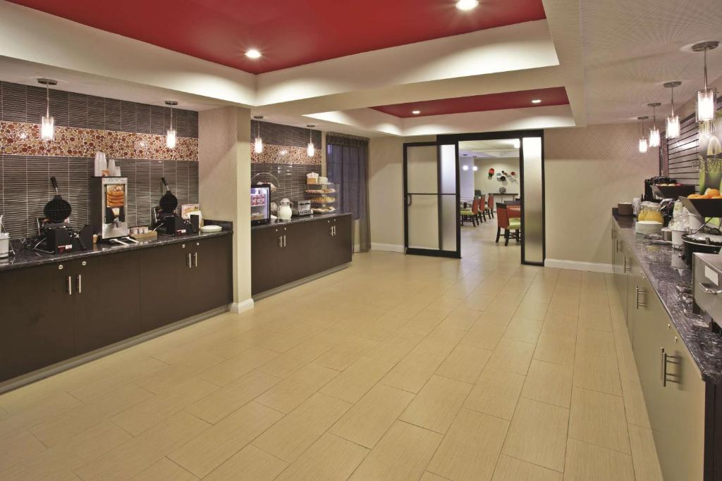 a lobby of a restaurant with a kitchen and a cafeteria at La Quinta Inn & Suites - New River Gorge National Park in Summersville