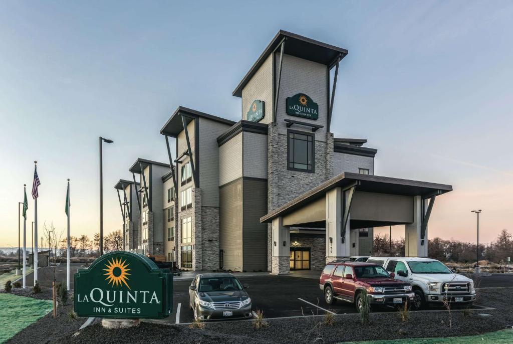 a building with two cars parked in front of it at La Quinta Inn & Suites by Wyndham Walla Walla in Walla Walla