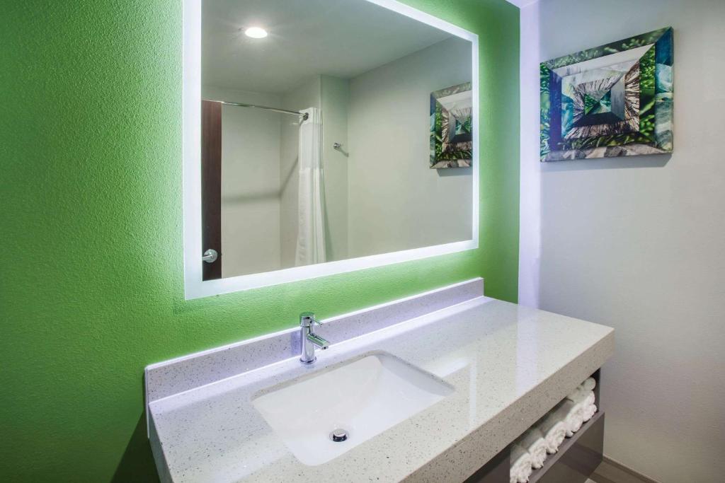 a bathroom with a sink and a mirror at La Quinta by Wyndham Owasso in Owasso