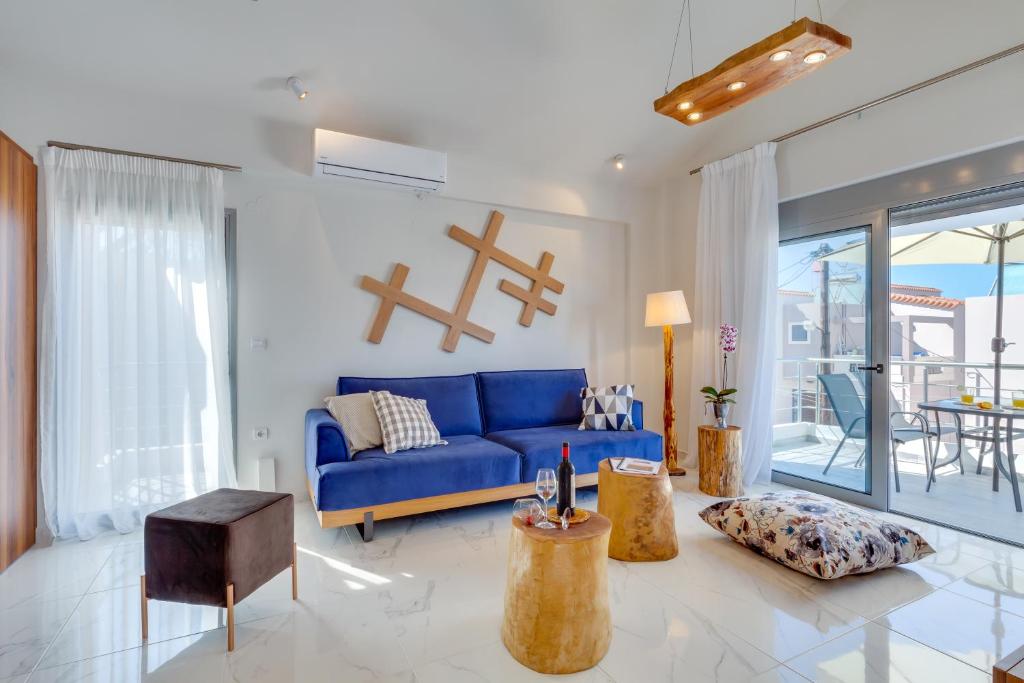a living room with a blue couch and a table at Ikia Aretousa in Kato Daratso