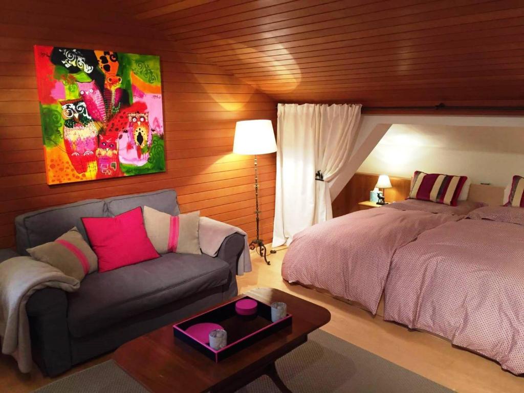 ein Schlafzimmer mit einem Bett und einem Sofa in der Unterkunft Apartment Cristina - Südbalkon mit Bergblick in Seefeld in Tirol