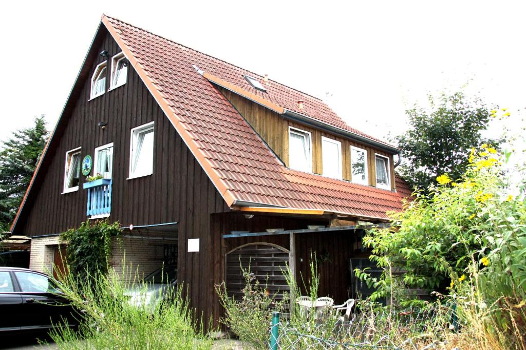une maison brune avec un toit rouge dans l'établissement Stöckmann, à Neuenkirchen