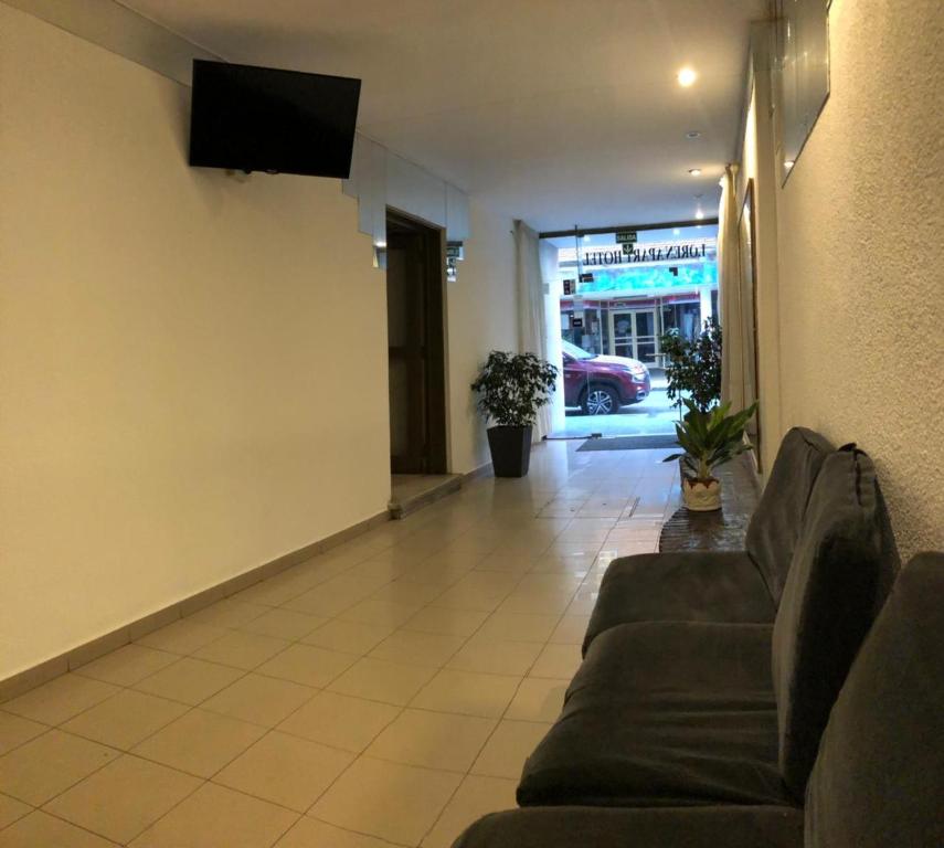sala de estar con sofá y TV de pantalla plana en Apart Loren en Córdoba