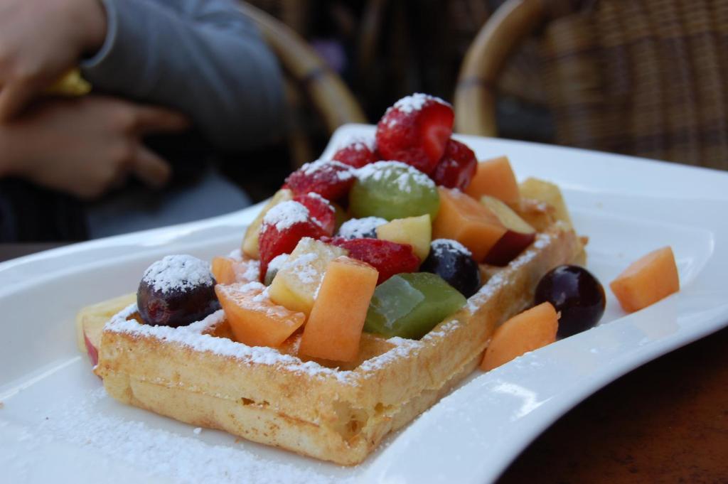 a waffle with fruit on a plate on a table at B&B 't Walleke in Bruges
