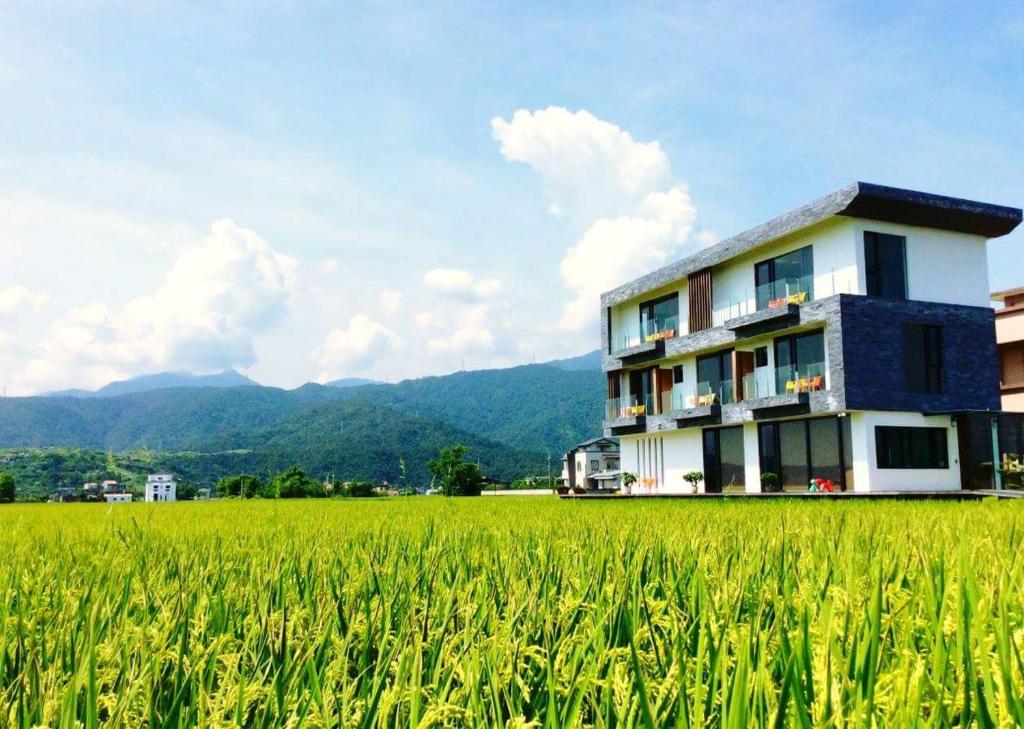 a building in the middle of a green field at Yuansu.MHL48 B&B in Dongshan