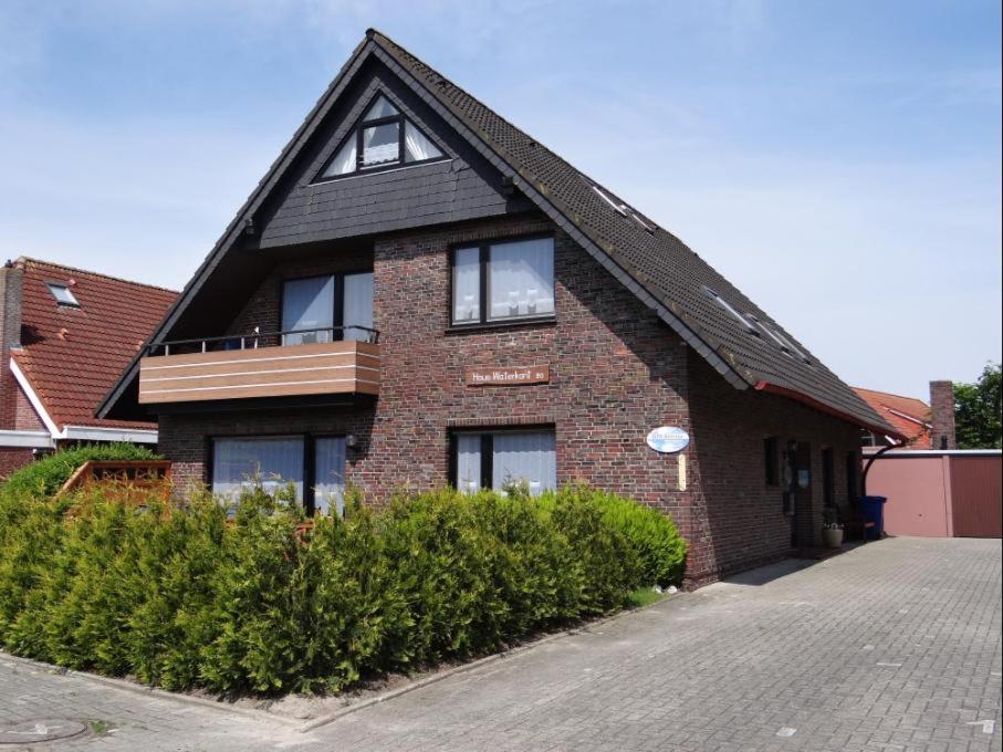 a brown brick house with a black roof at 50134... in Carolinensiel