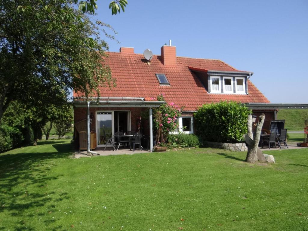 una casa con techo rojo y patio en 50141 Gretchen´s Hus 1, en Wangerland