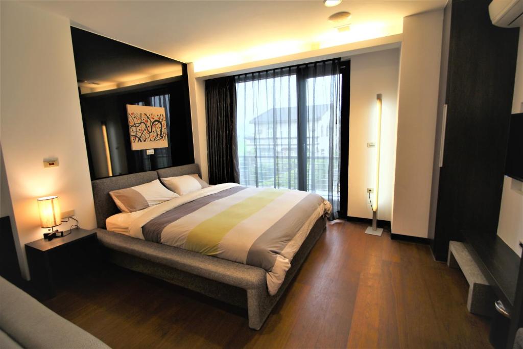 a bedroom with a large bed and a large window at The Designer&#39;s House in Wujie