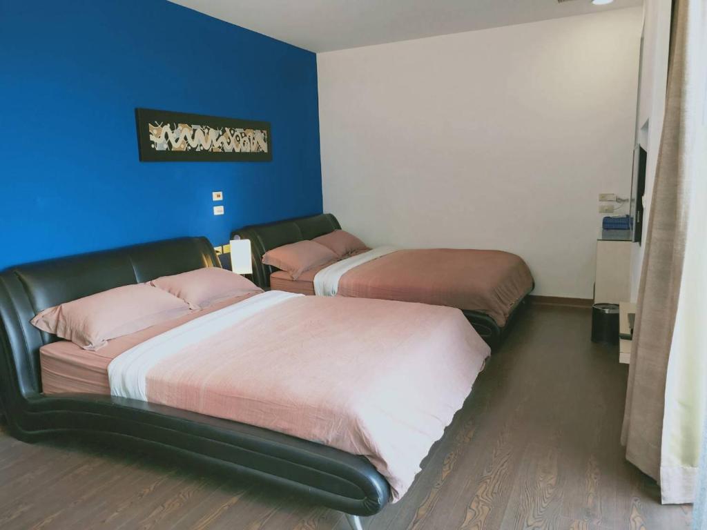two beds in a room with a blue wall at The Designer&#39;s House in Wujie