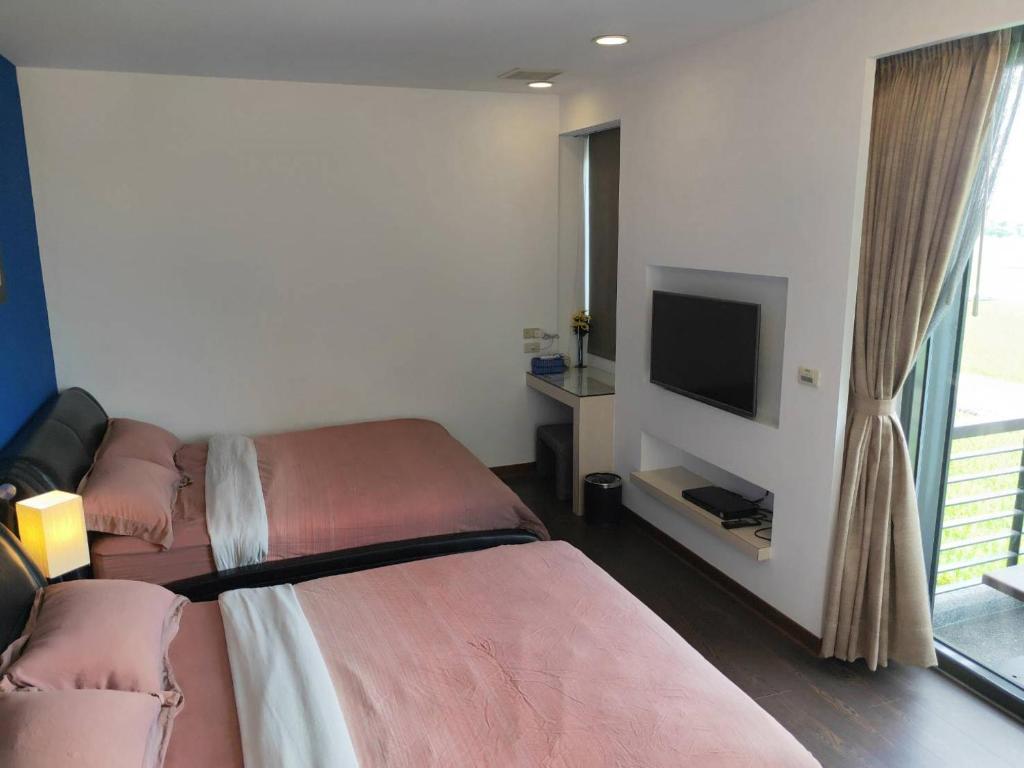 a hotel room with two beds and a flat screen tv at The Designer&#39;s House in Wujie