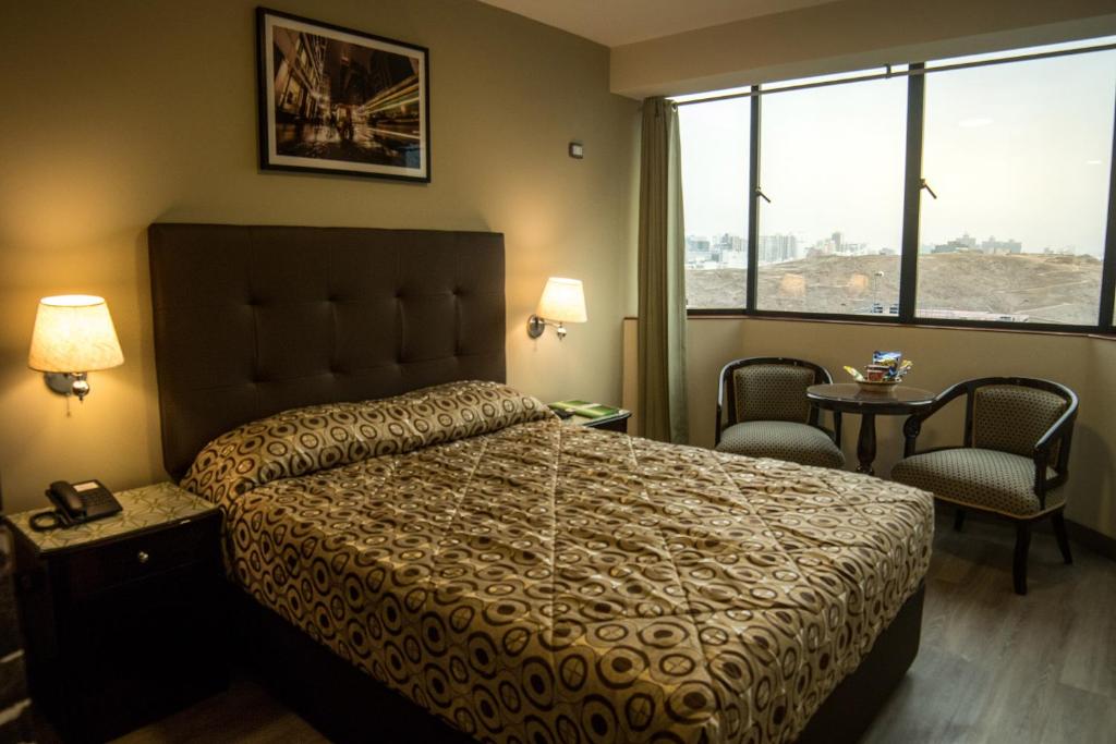 1 dormitorio con 1 cama, 2 sillas y ventana en Hotel Lexus, en Lima