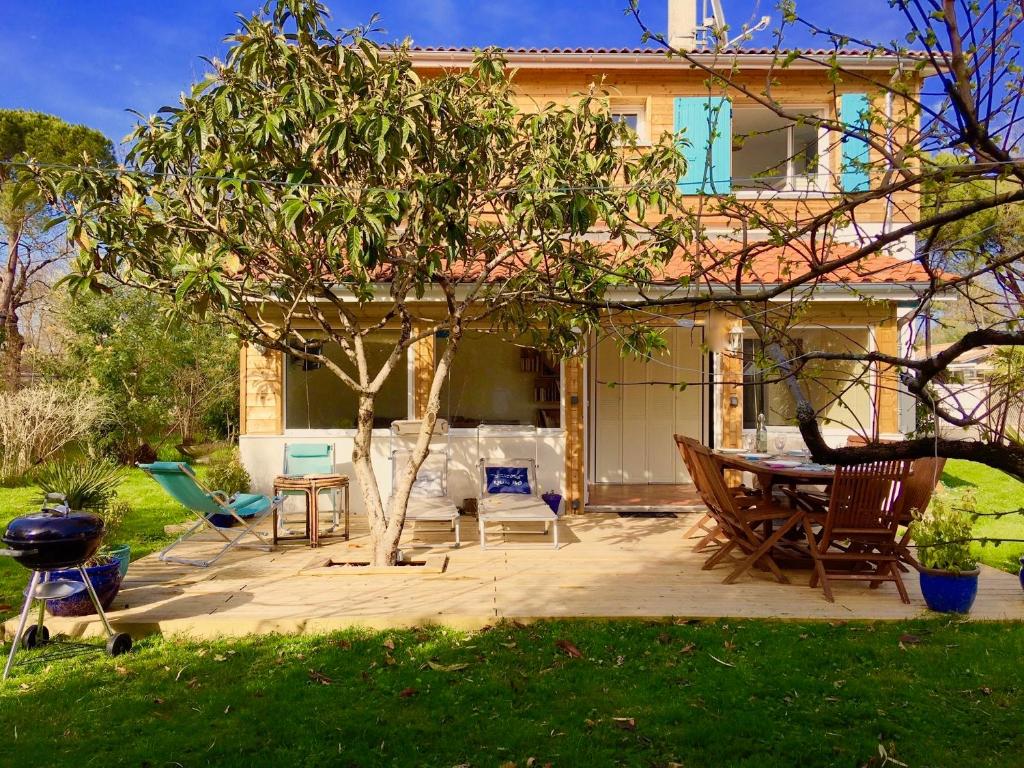 un patio avec une table et des chaises devant une maison dans l'établissement Villa Chez Pepe, à Andernos-les-Bains