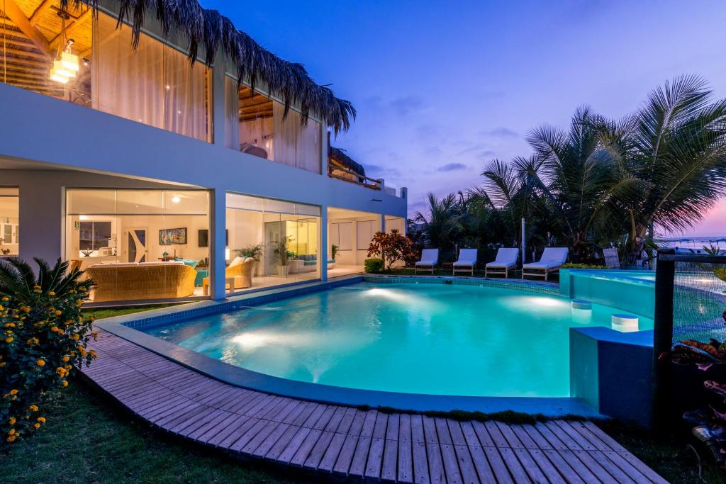 a swimming pool in the backyard of a house at Qalma Punta Sal in Canoas De Punta Sal