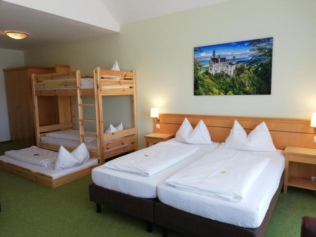 a hotel room with two beds and a bunk bed at Hotel Nummerhof in Erding