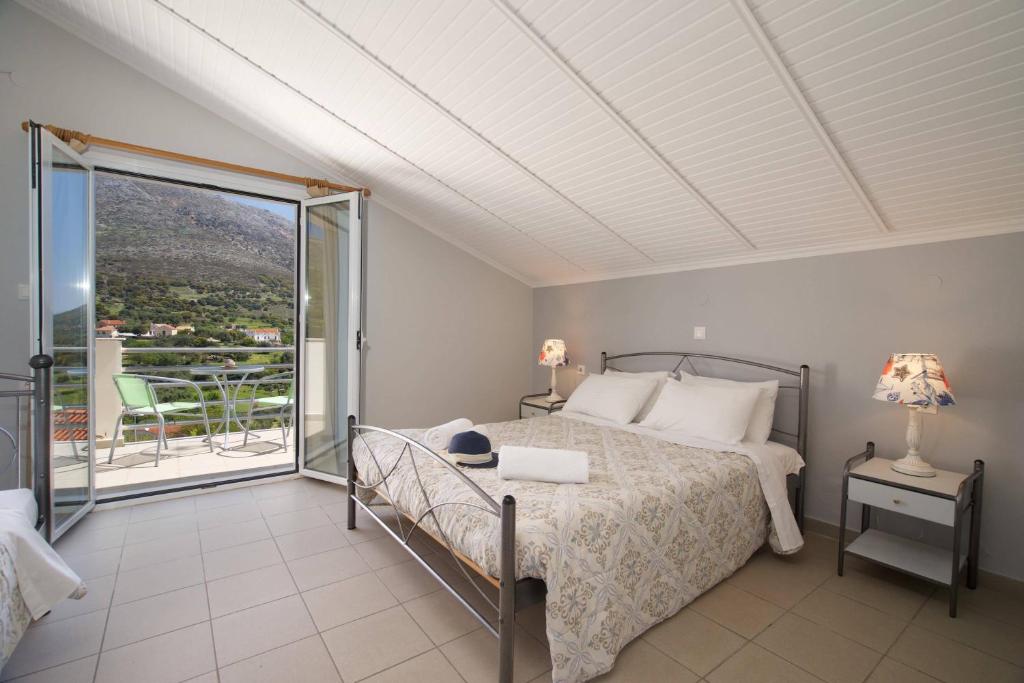 a bedroom with a bed and a balcony at Minas Apartments in Divarata