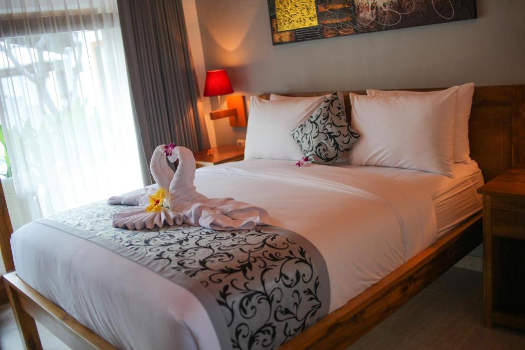 a bedroom with a bed with a swan on it at Villa Casablanca Surf Keramas in Keramas