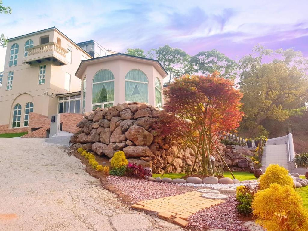 a large house with a rock wall in front of it at Moon Shine B&B in Touwu