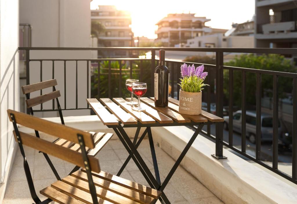 een tafel met twee glazen wijn en een fles wijn bij TownHall Apartment's in Rhodos-stad