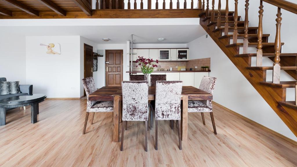 a kitchen and dining room with a wooden table and chairs at Apartamenty Sun & Snow Centrum in Zakopane