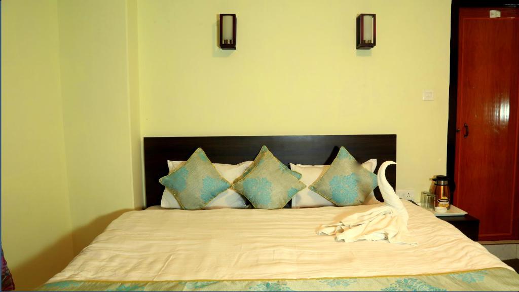 ein Bett mit blauen und weißen Kissen und einem Vogel darauf in der Unterkunft Mystic Valley Gangtok in Gangtok