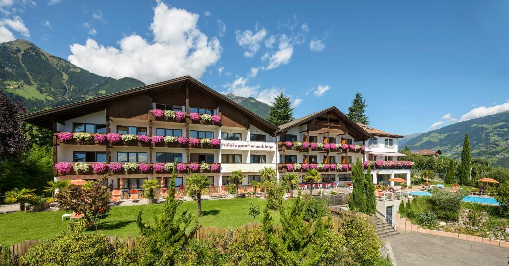 ein Hotel mit Pool und Bergen im Hintergrund in der Unterkunft Hotel Appartement Inge in Dorf Tirol