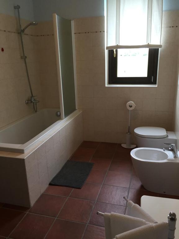 łazienka z wanną, toaletą i umywalką w obiekcie Agriturismo La Farazzina w mieście Oleggio