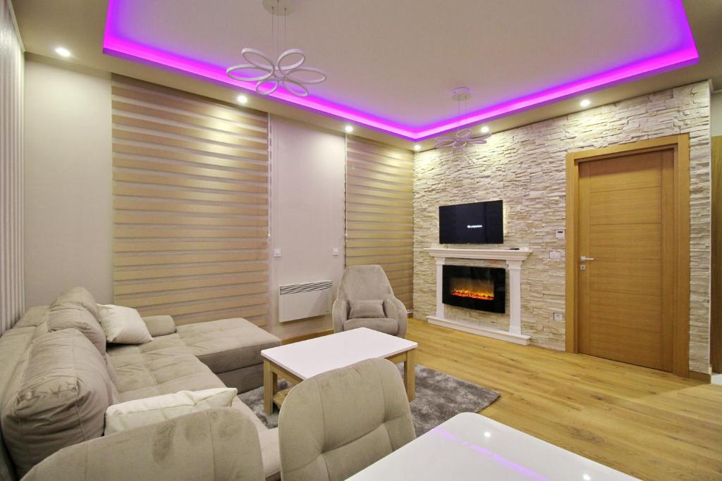 a living room with a couch and a fireplace at NK11 apartments in Zlatibor