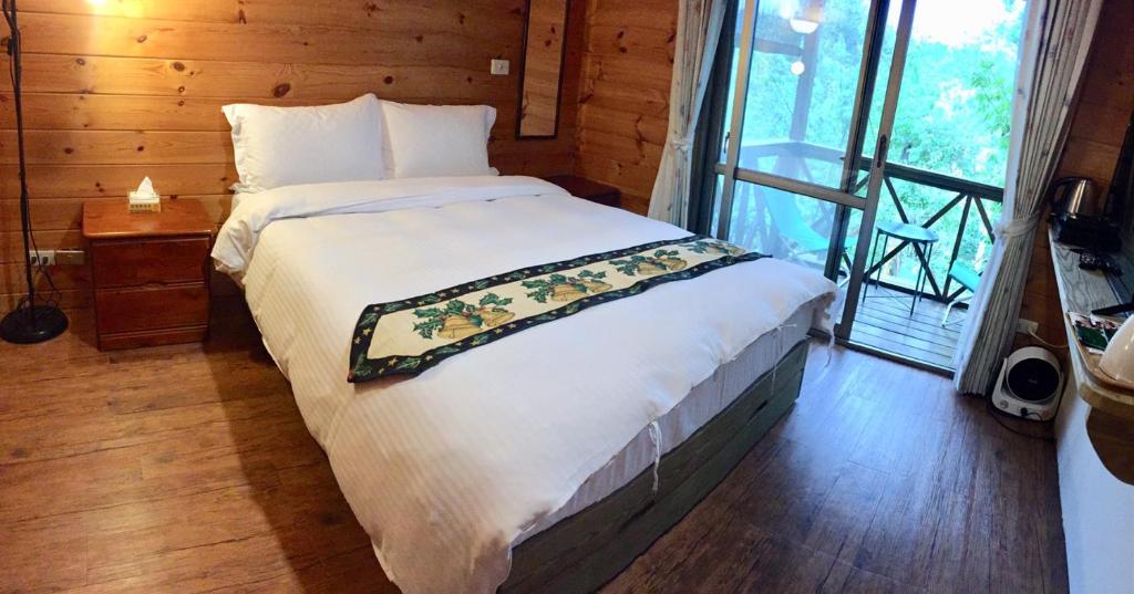 a bedroom with a bed and a large window at New Life Hot Spring Resort in Yuli