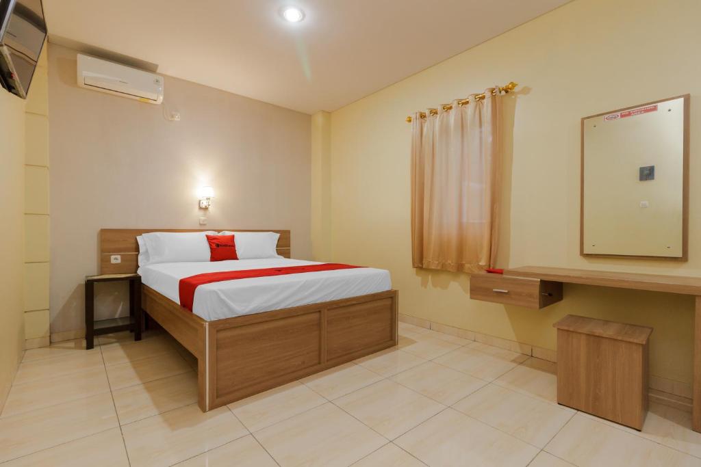 Tempat tidur dalam kamar di RedDoorz Plus near Pantai Malalayang Manado